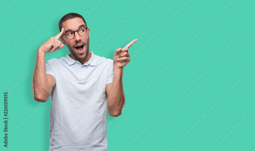 Happy young man with a gesture of having an idea and pointing with his hand Happy young man with a gesture of having an idea and pointing with his hand