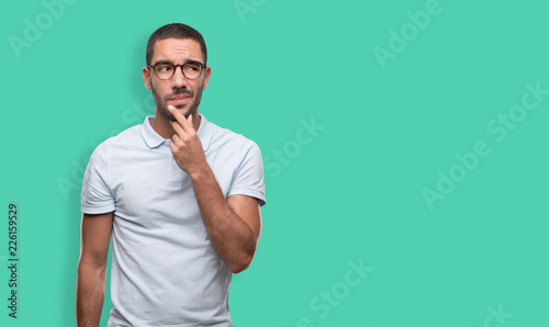 Confident young man with a gesture of doubt photo