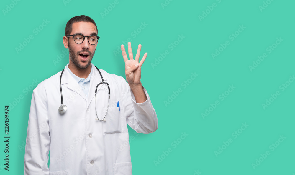 Confident young doctor with a gesture of number four Confident young doctor with a gesture of number four