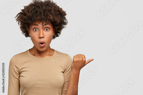 Bild auf Leinwand Waist up portrait of amazed emotional stupefied dark skinned woman holds breath,