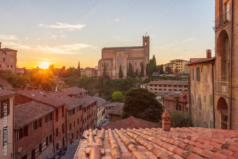 Cityscape of Siena (Tuscany, Italy) during the sunset; in the background the Basilica of San Domenico