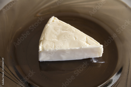 Obraz na płótnie A piece of processed cheese is on a glass plate w salonie