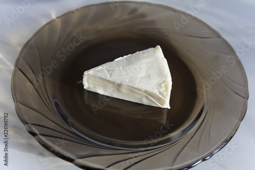 Obraz na płótnie A piece of processed cheese is on a glass plate w salonie