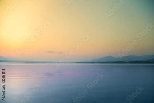 A beautiful  calm morning landscape of lake and mountains in the distance. Colorful summer scenery with mountain lake in dawn. Tatra mountains in Slovakia  Europe.