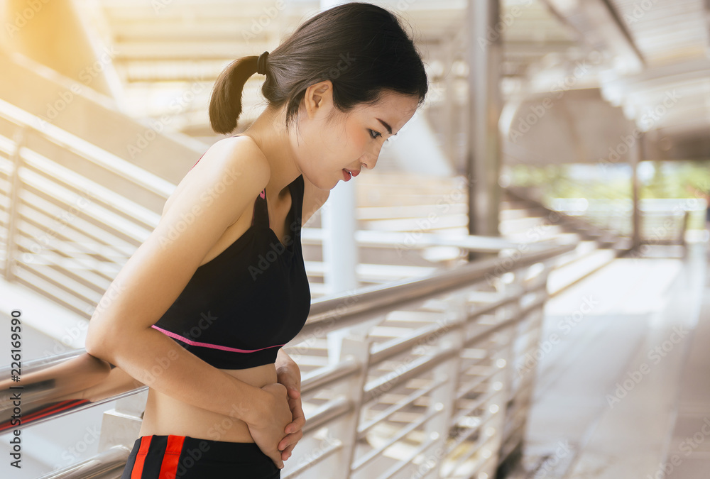 Woman suffering from pain and colic is a frequent problem after sport exercise running jogging and workout Woman suffering from pain and colic is a frequent problem after sport exercise running jogging and workout