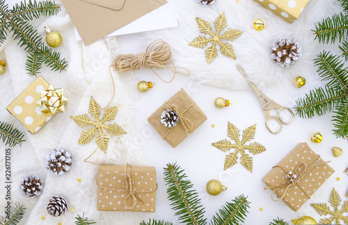 Homemade gift box decoration for Merry Christmas. DIY hobby. Boxes are wrapped in kraft paper, tied with twine with twigs, cones, gold snowflakes and fir tree. Original gift decoration flat lay