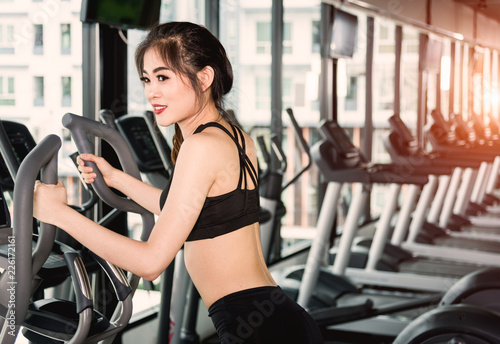 Young woman lifestyle using equipment machine elliptical for training cardio workout
