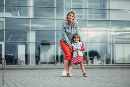 Beautiful Young Mother with Small Stylish Daughter Walks Through City Together © Romvy