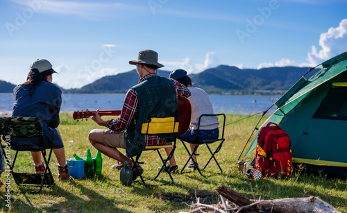 Back camping camp in nature happy friends group playing guitar in summer
