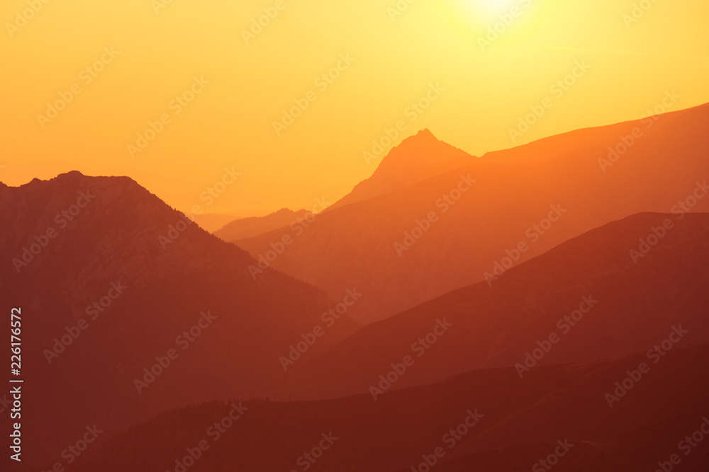 A beautiful minimalist landscape during the sunrise over mountains in warm tones. Abstract, colorful scenery of mountains in morning. Tatra mountains in Slovakia, Europe.