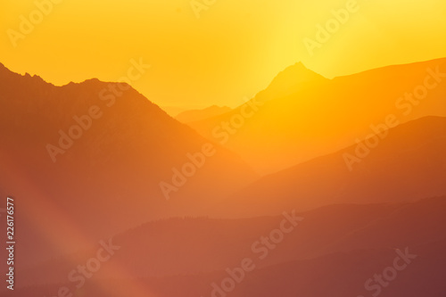 A beautiful minimalist landscape during the sunrise over mountains in warm tones. Abstract, colorful scenery of mountains in morning. Tatra mountains in Slovakia, Europe.
