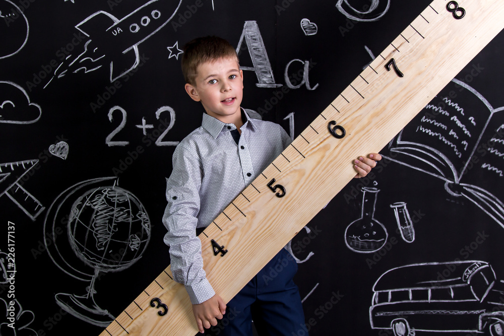 Handsome smiling schoolboy standing before the chalkboard as a ...