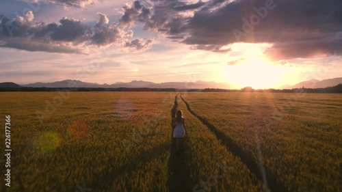 Wallpaper Mural Aerial - Behind a girl in a white dress running through field Torontodigital.ca