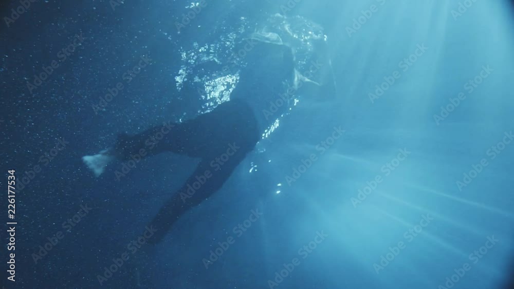 Amazing moving under the water a man dressed trying to get out from the pool and falling down again , dark time outside some lights falls into the water. Amazing moving under the water a man dressed trying to get out from the pool and falling down again , dark time outside some lights falls into the water.