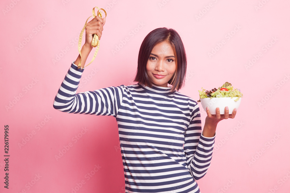 Healthy Asian woman with measuring tape and salad. Healthy Asian woman with measuring tape and salad.