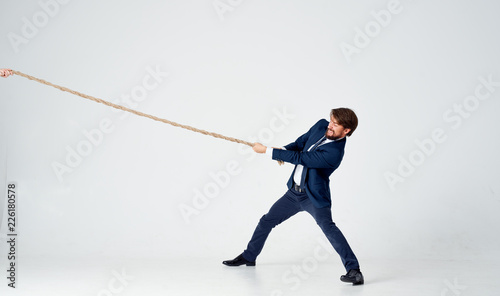 business man in suit pulls the rope