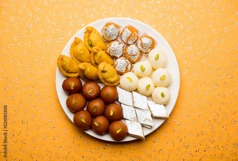 Indian sweets in a plate includes Gulab Jamun, Rasgulla, kaju katli