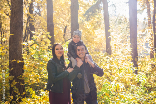 Children, nature and family concept - Portrait of happy family over autumn park background