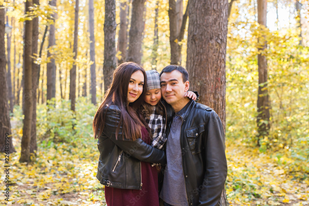 Children, nature and family concept - Portrait of happy family over autumn park background