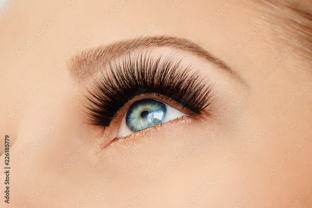 Fototapeta premium Female eye with extreme long false eyelashes and black liner. Eyelash extensions, make-up, cosmetics, beauty