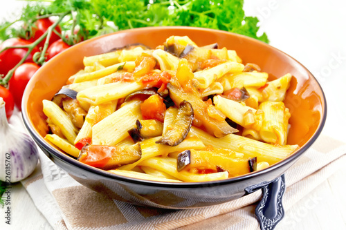 Pasta penne with eggplant and tomatoes on table
