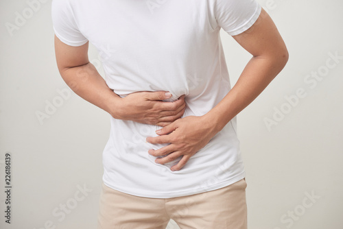people, healthcare and health problem concept - unhappy man suffering from stomach ache over white background