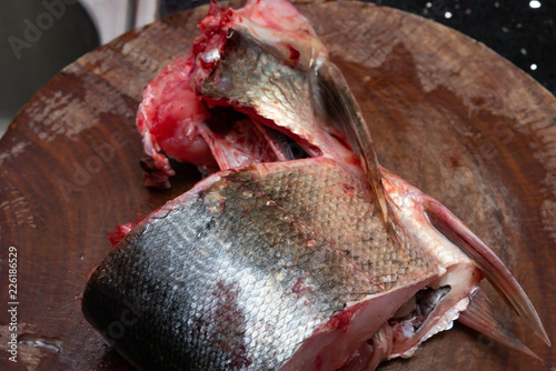 cutting slice of raw fish on chopboard photo