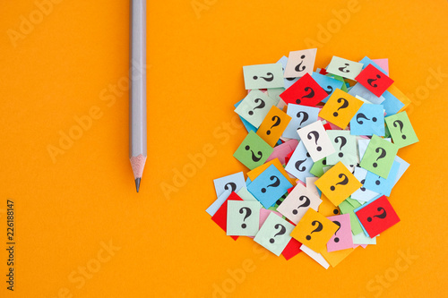 Pencil and question marks on yellow background