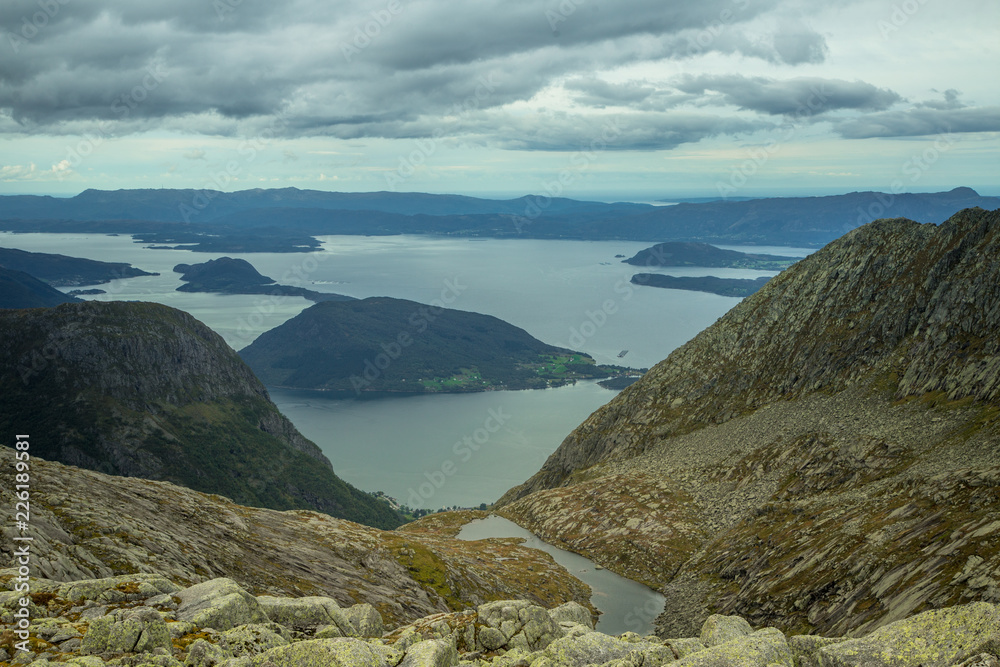A beautiful autumn landscape of mountains in Folgefonna National park with fjord far in the distance. Fall scenery of southern Norway, Autumn colors in overcast day. A beautiful autumn landscape of mountains in Folgefonna National park with fjord far in the distance. Fall scenery of southern Norway, Autumn colors in overcast day.