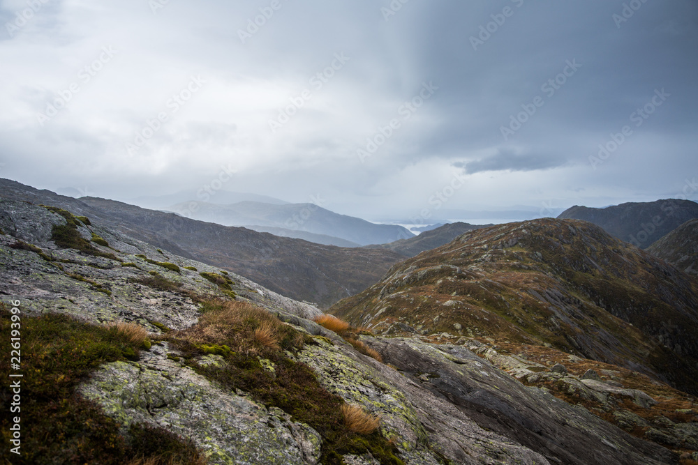 A beautiful autumn landscape in Folgefonna National Park in Norway during a hike in windy, rainy weather. Mountains in Scandinavia. Autumn scenery in wilderness. A beautiful autumn landscape in Folgefonna National Park in Norway during a hike in windy, rainy weather. Mountains in Scandinavia. Autumn scenery in wilderness.