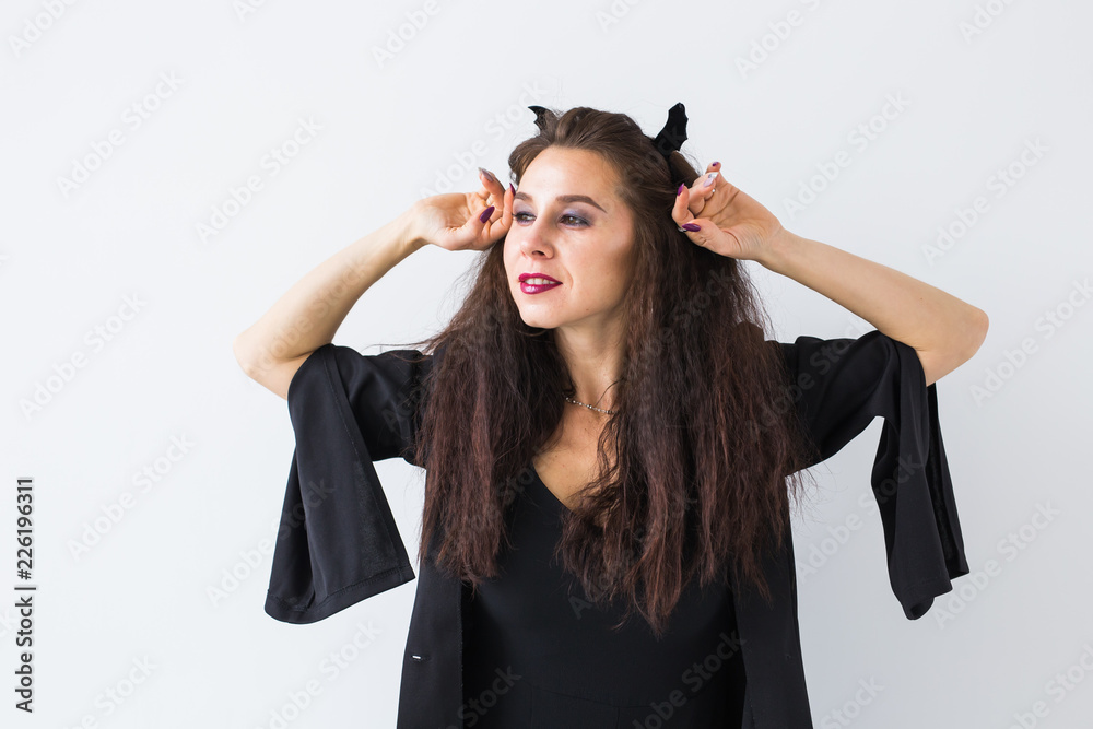 Cute gothic woman in halloween style clothes in light background Cute gothic woman in halloween style clothes in light background