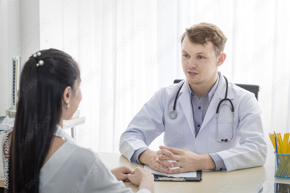 Medical professionals caucasian man reassuring and talking with young woman stress patient.Close up and copy space. Medical professionals caucasian man reassuring and talking with young woman stress patient.Close up and copy space.