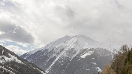 Zooming in time lapse shot of the Kalser valley in Osttirol, Austria, during a day with sun, clouds and fresh snow fall.