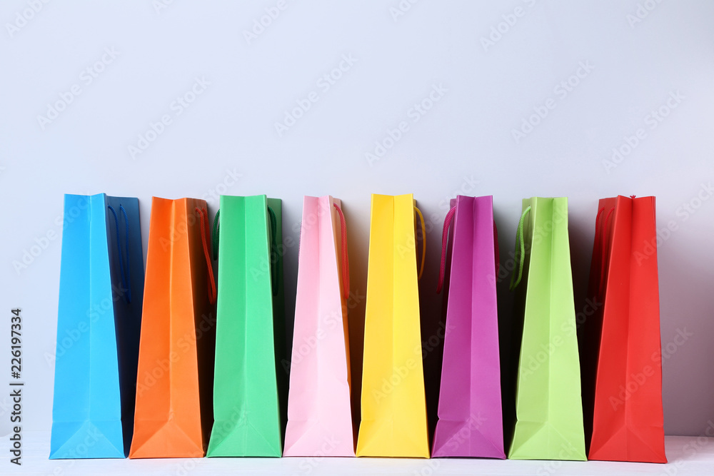 Colorful paper shopping bags on grey background
