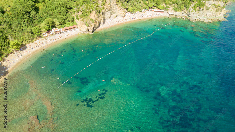 Aerial view of swimming people at sunrise . Mediterranean sea. Transparent water. Top view from flying drone