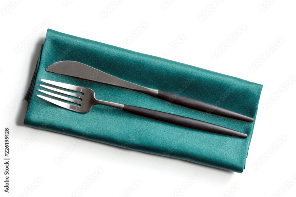 Knife and fork on a napkin on a white background Knife and fork on a napkin on a white background