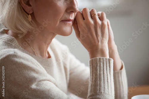 Close up view of thoughtful mature woman worried concerned about problems or disease  middle aged grey haired senior lady getting older thinking of loneliness depression grief anxiety concept
