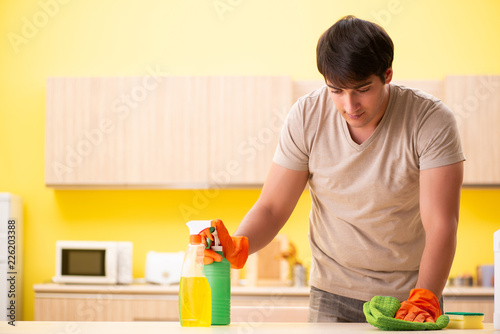 Single man cleaning kitchen at home