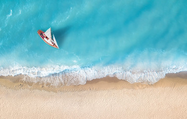 Yacht on the water surface from top view. Turquoise water background from top view. Summer seascape from air. Travel concept and idea