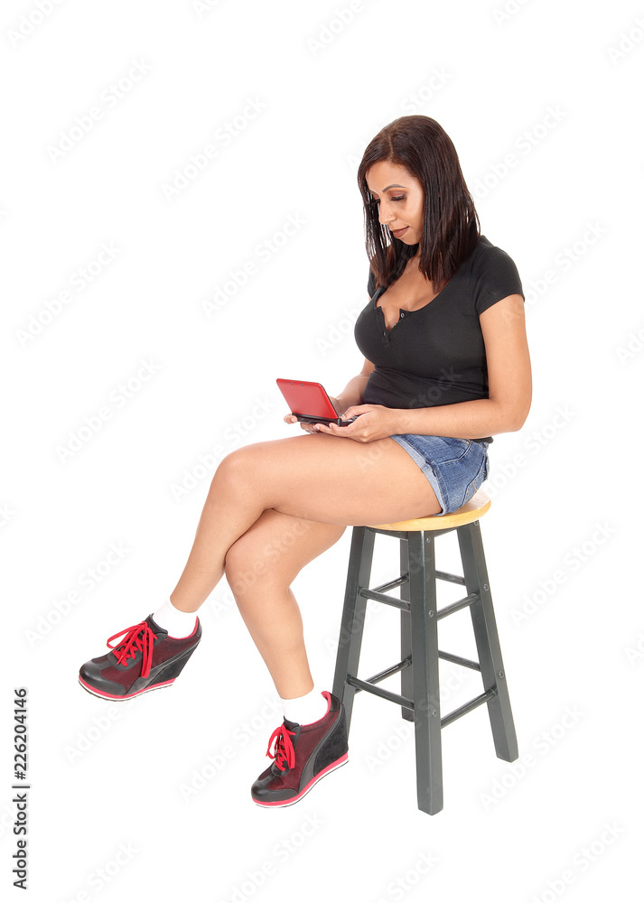 Woman sitting on chair, playing with her game Woman sitting on chair, playing with her game