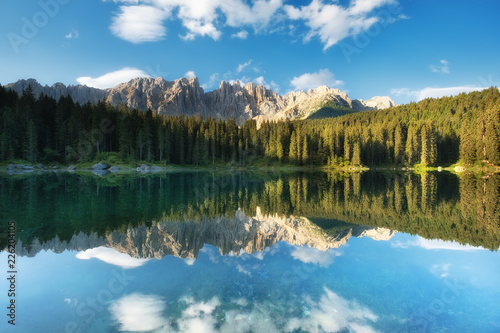 Mountains and forest reflection on the water surface. Natural landscape in the Dolomites Alps in the Italy