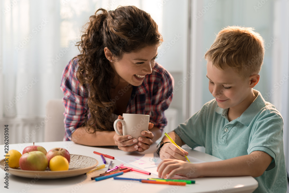 Smiling mother and son coloring together Smiling mother and son coloring together