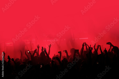 Valokuva Red background with a crowd of cheering people at a concert