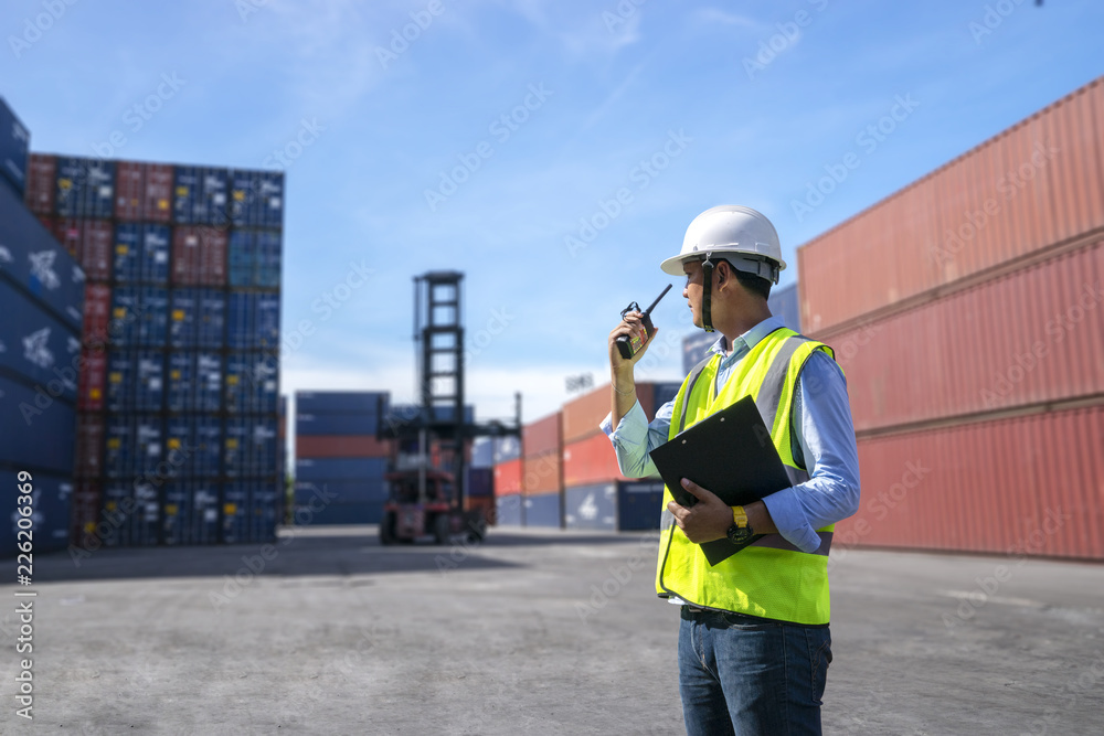 Foreman control loading Containers box to truck for Logistic Import Export Background Foreman control loading Containers box to truck for Logistic Import Export Background