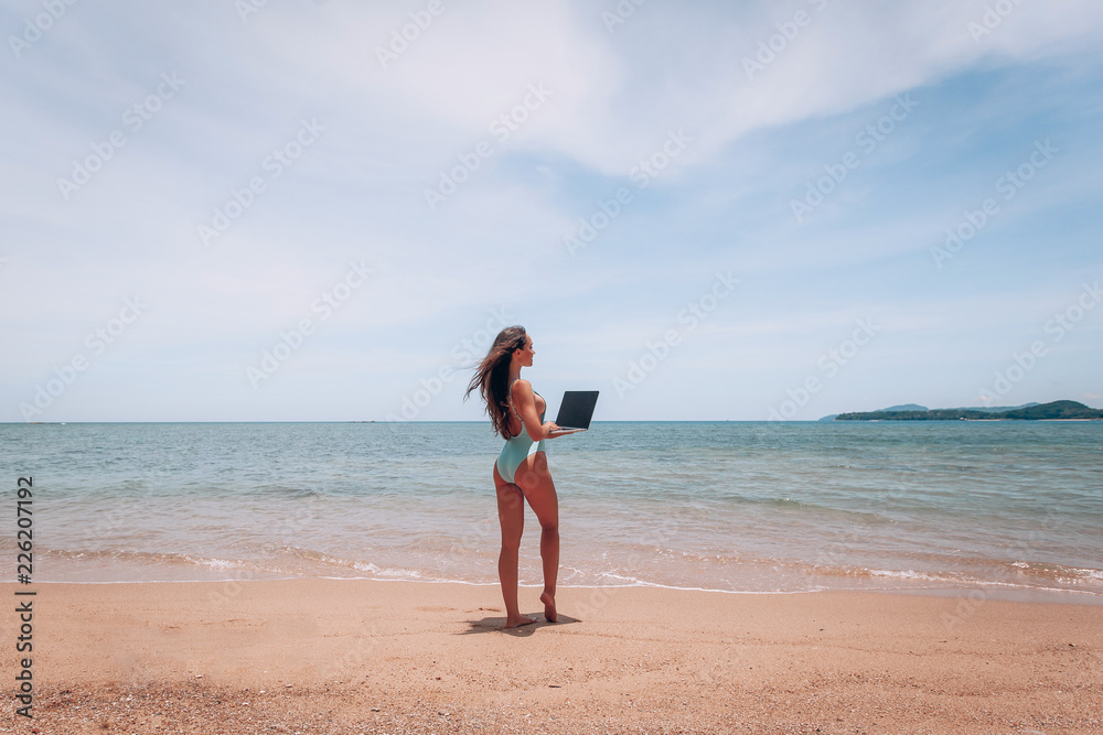 Young caucasian woman working with laptop on beautiful beach in Thailand Concept of resting on morning sea and summer vacations, modern technology. Young caucasian woman working with laptop on beautiful beach in Thailand Concept of resting on morning sea and summer vacations, modern technology.