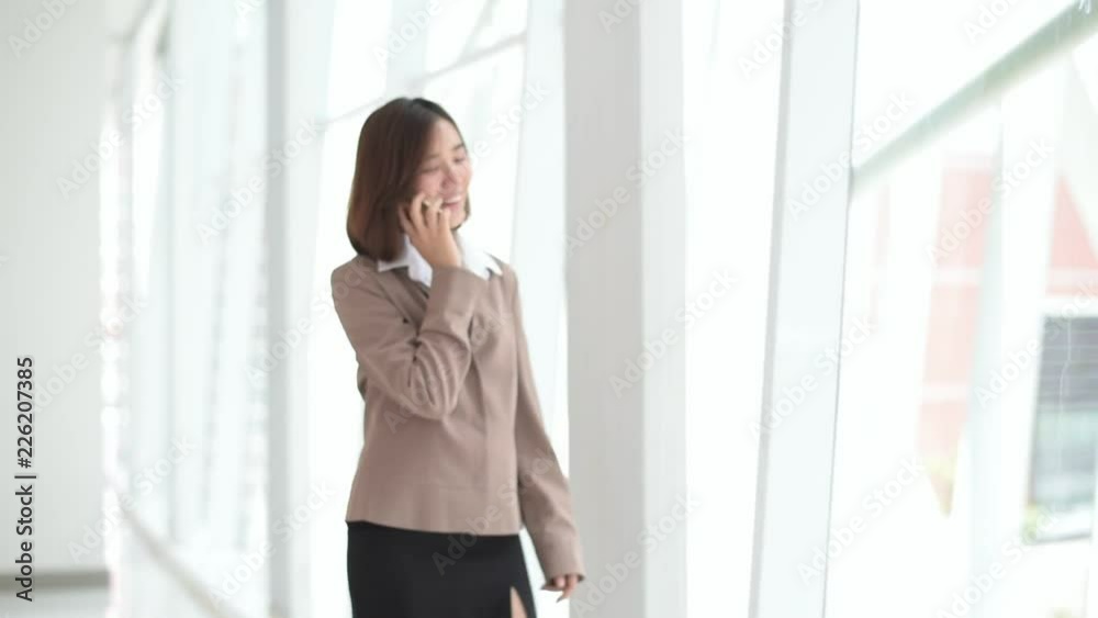 Young Asian woman walk and talk by smartphone Young Asian woman walk and talk by smartphone