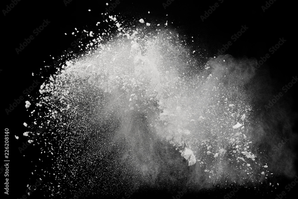 White powder or flour explosion isolated on black background; freeze stop motion object design
