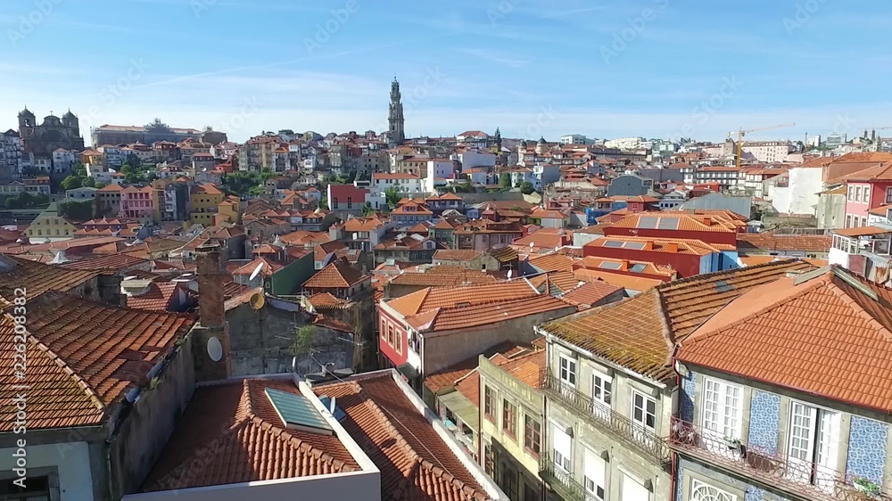 Aerial motion video on view of orange rooftops and historical buildings of the old city and Clerigos church tower of Porto, Portugal