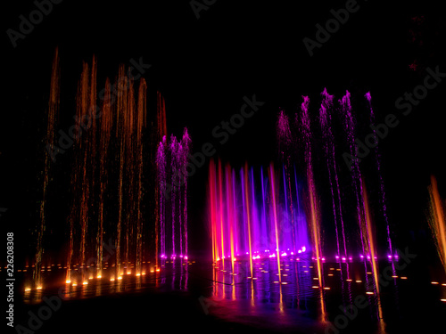  colored decorative dancing water jet led light fountain show at night © Netfalls
