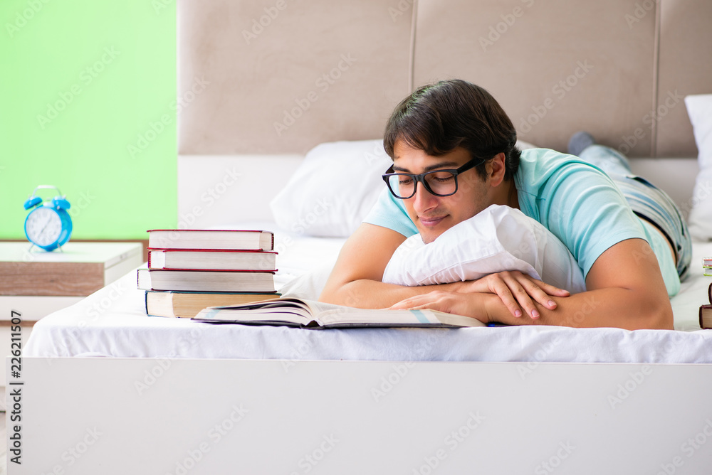 Student preparing for exams at home in bedroom lying on the bed Student preparing for exams at home in bedroom lying on the bed